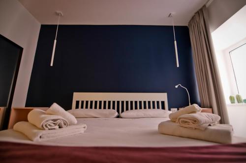 - une chambre avec un grand lit et des serviettes dans l'établissement Bovio 33 Napoli art apartment, à Naples