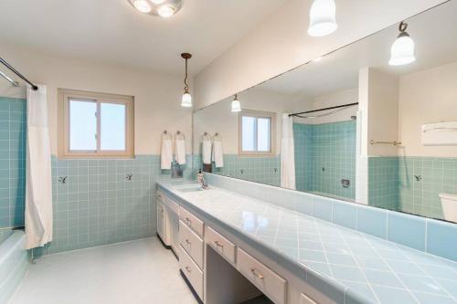 baño con lavabo grande y espejo grande en Casa Flora -2BR- FREE Parking in Little Italy!, en San Diego