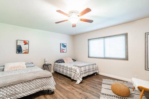 a bedroom with two beds and a ceiling fan at Casa Flora -2BR- FREE Parking in Little Italy! in San Diego