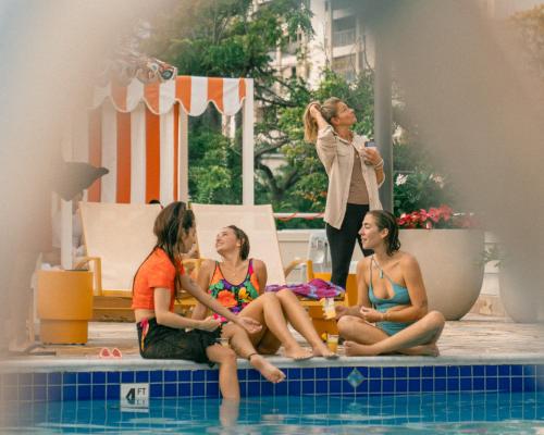 - un groupe de femmes assises autour d'une piscine dans l'établissement Romer Waikiki at The Ambassador, à Honolulu