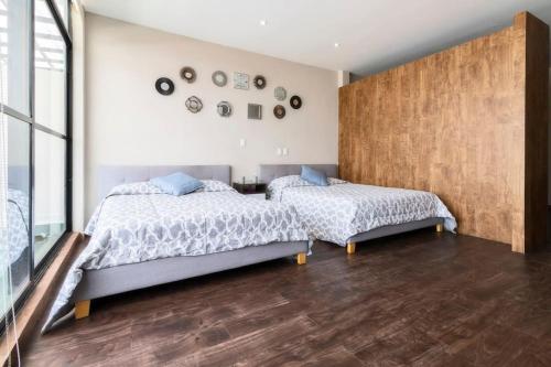 two beds in a bedroom with wooden floors at 602 Private Terrace apt AC Rooftop in Mexico City