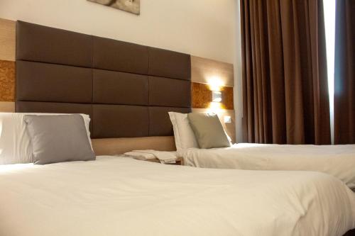 a hotel room with two beds and a headboard at Hotel 999 in Prato