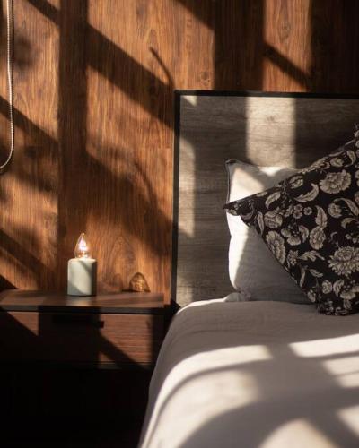 a bed with a pillow and a candle on a night stand at 202 Walk the City Center 1bdrm 2bath AC Apt in Mexico City