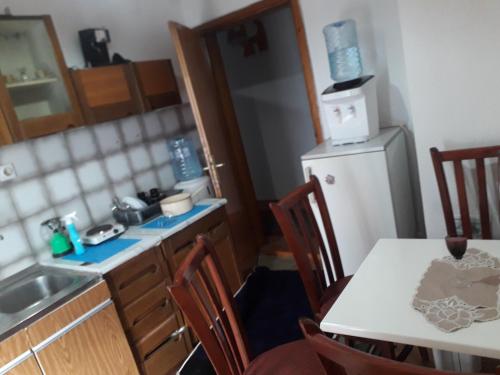 una pequeña cocina con mesa y nevera en Apartman Struga, en Struga