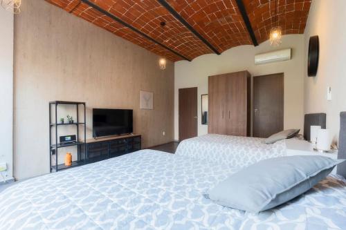a large bedroom with a large bed and a television at 205 Zocalo Cathedral 2bdrmB 2Bath fits 10 AC Apt in Mexico City