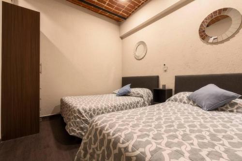 a bedroom with two beds and a mirror on the wall at 205 Zocalo Cathedral 2bdrmB 2Bath fits 10 AC Apt in Mexico City