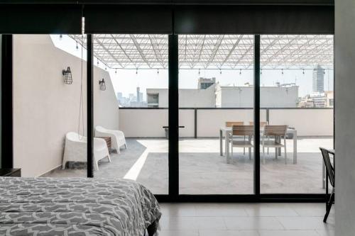 a bedroom with a bed and a table and a balcony at 1PH Hidden gem in Centro Fits 10 private terrace in Mexico City
