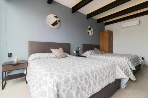 1 dormitorio con 2 camas y reloj en la pared en 1PH Hidden gem in Centro Fits 10 private terrace, en Ciudad de México