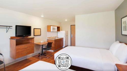 a hotel room with a bed and a television at Woodspring Suites Huntsville/ Madison in Madison