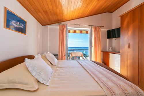 a bedroom with a large bed with a large window at Guest house Lenka in Brela