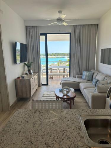 uma sala de estar com um sofá, uma mesa e uma televisão em Hermoso Apart @the Beach Punta Cana em Punta Cana