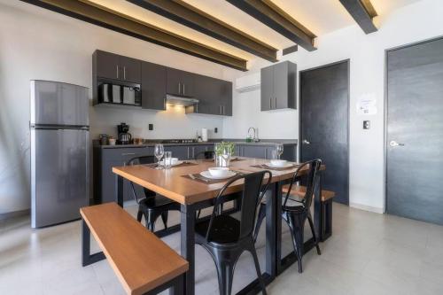 a kitchen with a wooden table and black cabinets at 3Ph Amazing 2Bdrm 2bath private terrace fits 10 in Mexico City