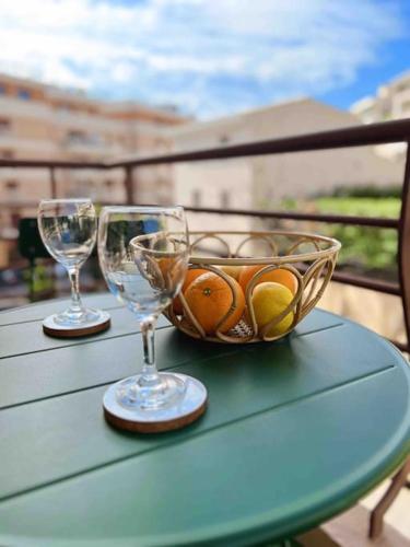 - deux verres à vin et un bol de fruits sur une table dans l'établissement Le Diderot : Apt 2 Prs, 10 min plages, parking, à Antibes