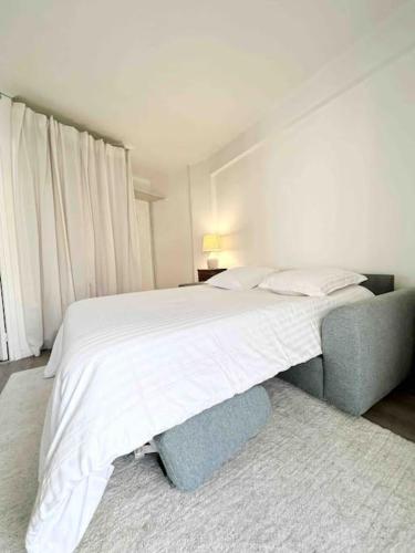 - une chambre avec un lit blanc et un canapé bleu dans l'établissement Le Diderot : Apt 2 Prs, 10 min plages, parking, à Antibes