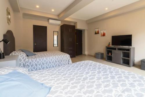a bedroom with two beds and a flat screen tv at 206 Zocalo Cathedral 2Bdrm 2Bath apt AC Rooftop in Mexico City