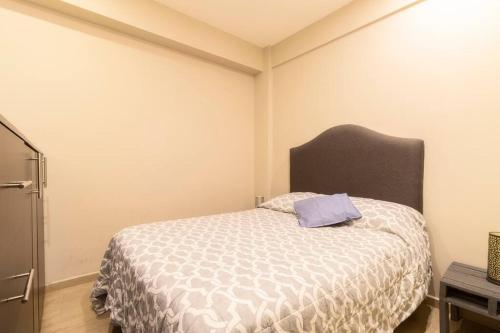 a bedroom with a bed with a purple pillow on it at 206 Zocalo Cathedral 2Bdrm 2Bath apt AC Rooftop in Mexico City