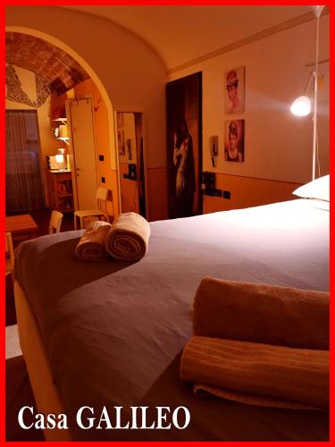 a bedroom with a bed with two towels on it at Casa GALILEO- Antiche Dimore Pisane in Pisa