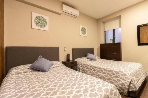 a room with two beds in a room at 204 Historic Center 2Bdrm 2Bath AC Apt Rooftop in Mexico City