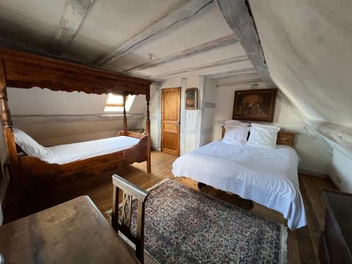 1 dormitorio con 2 camas, mesa y silla en Gîte du Brocanteur, en Scherwiller