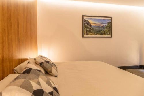 Un dormitorio con una cama con un cuadro en la pared. en Zielo Studio apt 2Bdrm 1bath fits 6 AC Rooftop, en Ciudad de México