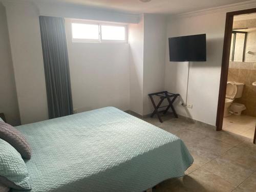 a bedroom with a bed and a flat screen tv at Juan de la vega in La Vega