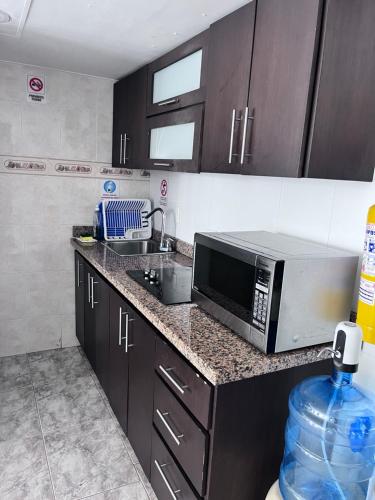 a kitchen with a microwave and a sink at Apartamento En San Andres in San Andrés
