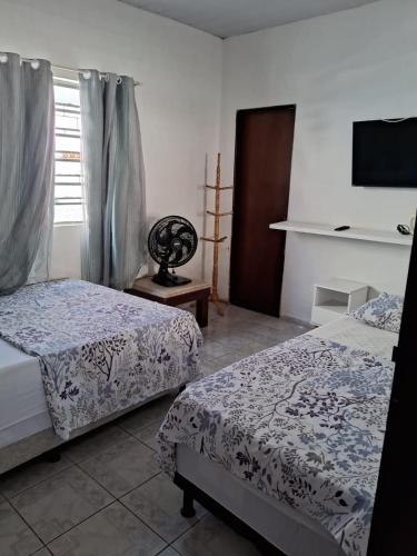 a bedroom with two beds and a window at Casa Catuçaba in Marechal Deodoro