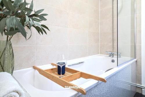 uma casa de banho com uma banheira com uma bandeja de madeira em Penkhull House by Truestays - 4 Bedroom House in Stoke-on-Trent em Stoke-on-Trent