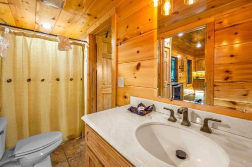 a bathroom with a sink and a toilet and a mirror at Heavenly Heights by Ghosal Luxury Lodging in Sevierville