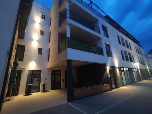 een wit gebouw met lichten aan de zijkant bij Apartman N&N in Koprivnica
