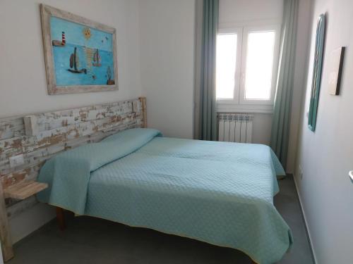 - une chambre avec un lit et une couverture bleue dans l'établissement L'Oasi di Giulia, à Olbia