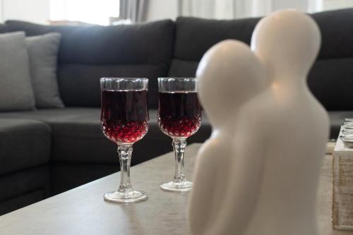two glasses of red wine sitting on a table at EMVI APARTMENTS IV seaview near airport in Artemida