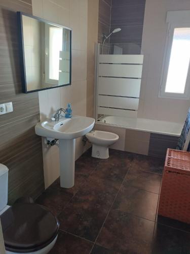 a bathroom with a sink and a toilet and a mirror at La Casa de Maia in Freila