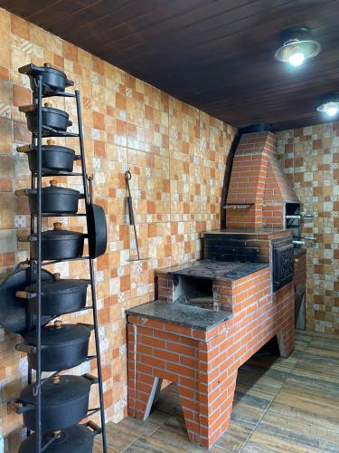 a brick oven with a ladder next to a brick wall at Casa baiana in Itatiaia