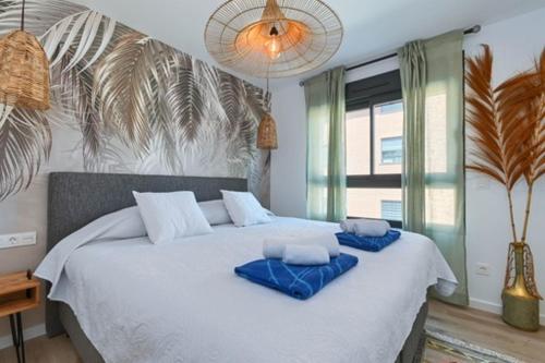a bedroom with a large bed with blue pillows on it at Boho chic in Jávea