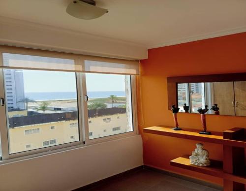 a room with two windows with a view of the beach at Apartamento en La mejor zona de Pampatar. in Pampatar