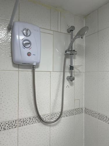 um chuveiro na casa de banho com uma cabeça de chuveiro em Becky's Lodge - Strictly Single Adult Room Stays - No Double Adult Stays Allowed em Solihull