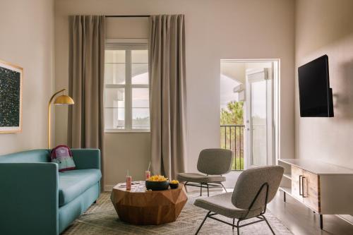 ein Wohnzimmer mit einem blauen Sofa und Stühlen in der Unterkunft Sonder at Vista Cay in Orlando