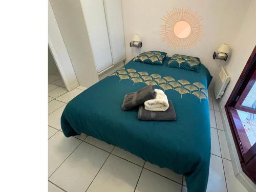 - une chambre avec 2 lits et une serviette sur le lit dans l'établissement le Signoret, à Aix-en-Provence