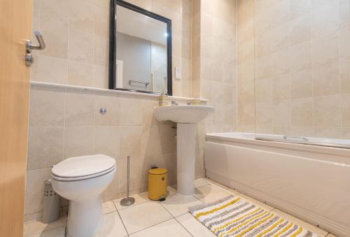 een badkamer met een toilet, een wastafel en een spiegel bij Contractors & Professionals Look No Further in Leicester