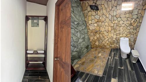 ein Bad mit einem WC und einer Steinmauer in der Unterkunft Suite Jr Aire de Montaña 6 - Hot Springs in Ahuachapán