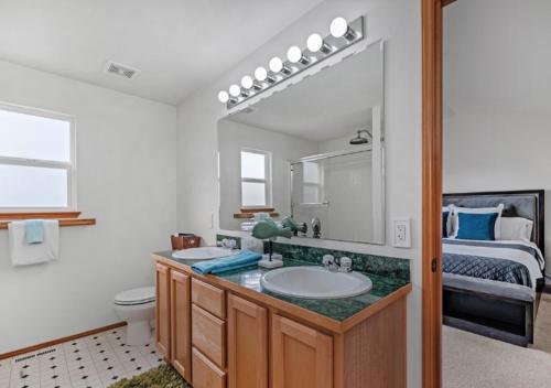 ein Badezimmer mit Waschbecken und Spiegel und einem Bett in der Unterkunft New Ridge View Marysville 3 beds 2 baths in Marysville