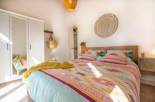 - une chambre avec un lit et une couette colorée dans l'établissement CASA LUNA en Playa de El PALMAR, à El Palmar