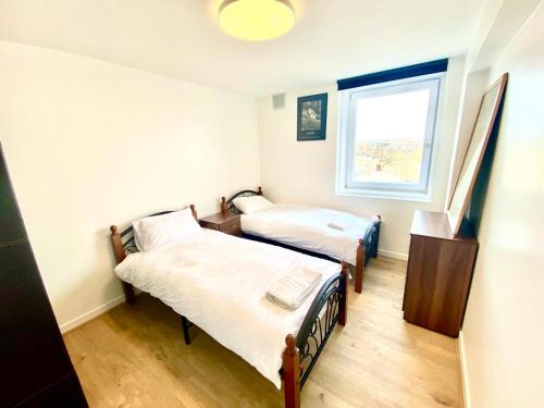 Zimmer mit 2 Betten und einem Fenster in der Unterkunft Comfy Two bedroom Flat Edgeware Road In Central London in London