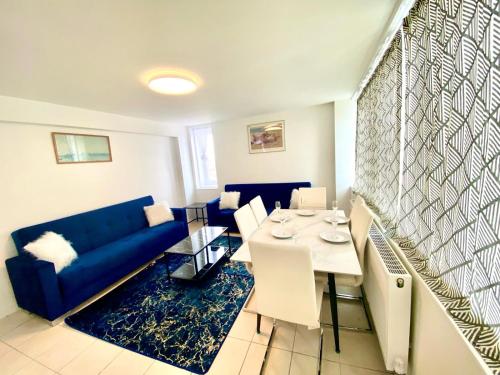 ein Wohnzimmer mit einem blauen Sofa und einem Tisch in der Unterkunft Comfy Two bedroom Flat Edgeware Road In Central London in London