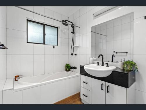 a white bathroom with a tub and a sink at Atherton Tablelands -great views & pet friendly in Tolga