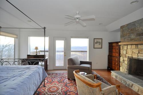 1 dormitorio con 1 cama y chimenea en Panorama Peak View- Million Dollar View!, en Berkeley Springs