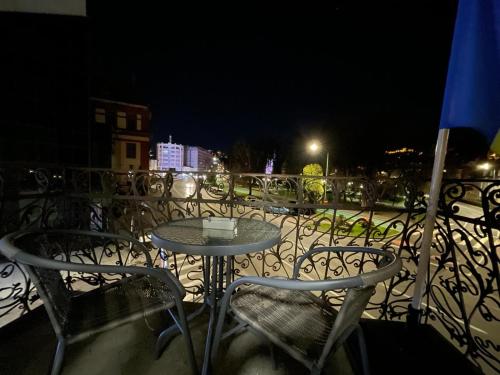 a table and chairs on a balcony at night at Resedinta Cina in Braşov