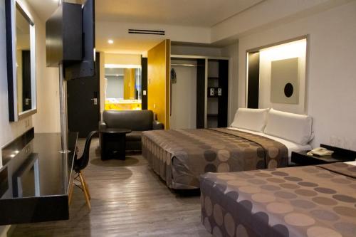 ein Hotelzimmer mit zwei Betten und einem Stuhl in der Unterkunft Hotel Harare in Mexiko-Stadt