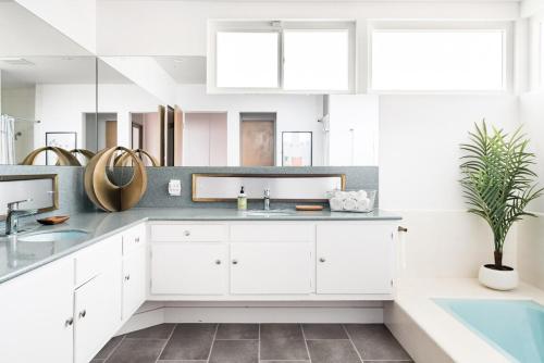 a bathroom with white cabinets and a sink at LA Huge Mid Century Guesthouse Patio LAX Beach in Los Angeles